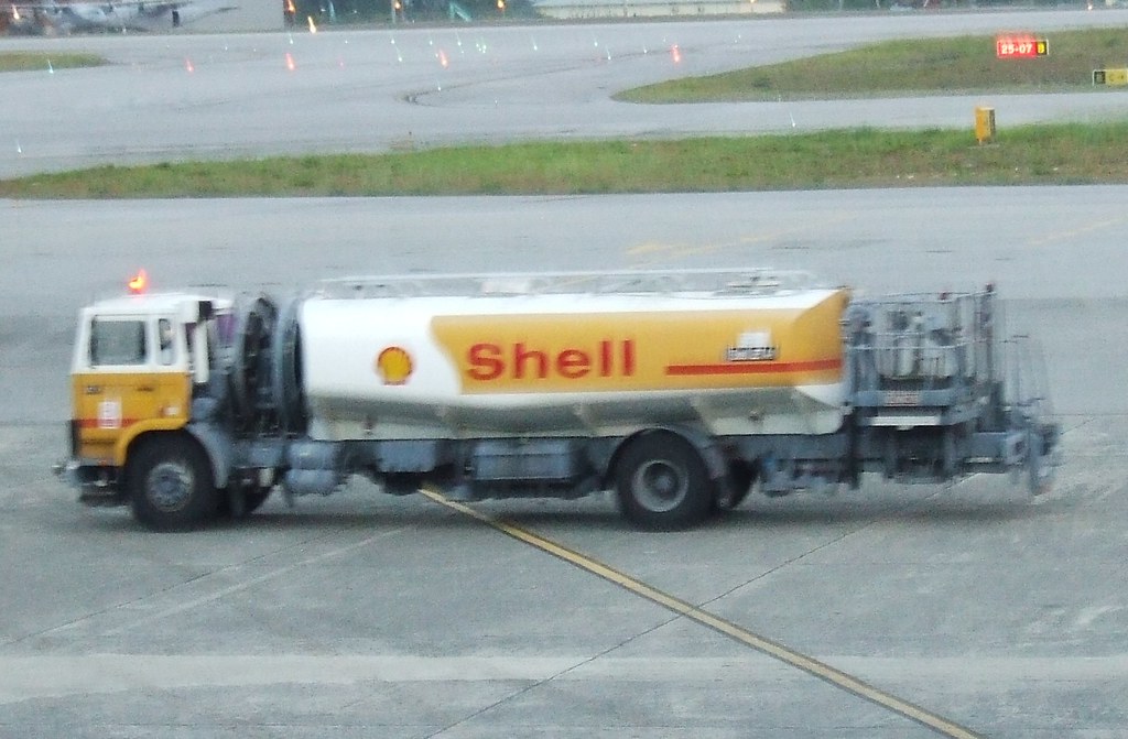 A road fuel tanker in Shell livery standing on an apron.